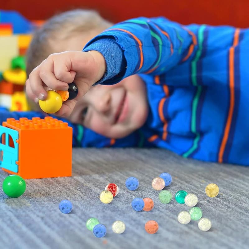 Bunte Glasmurmeln im Dunkeln leuchtend für Murmelbahn-Spiel